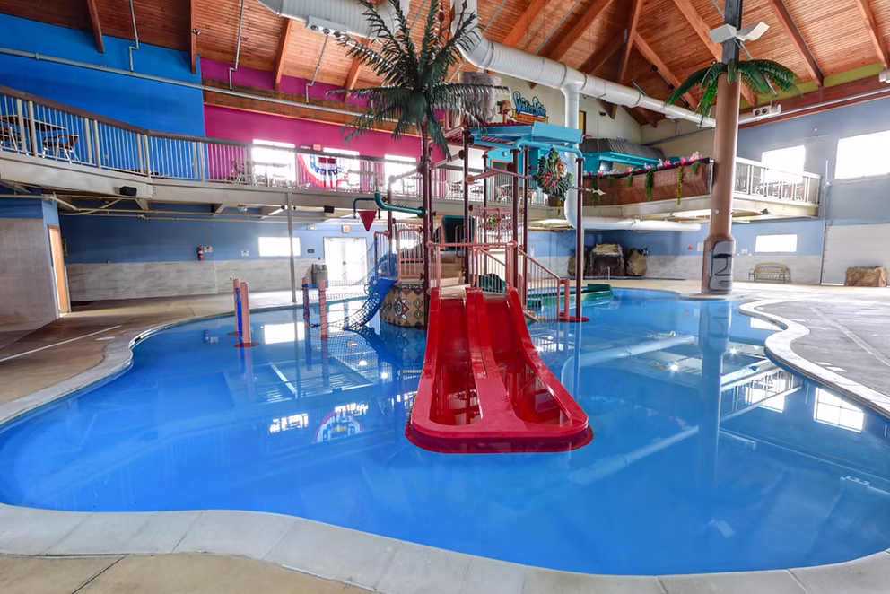 Splash pool with a red slide and palm tree decor