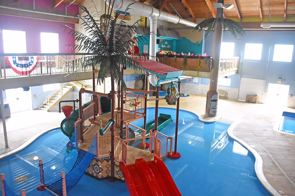 Children's play structure with slides over a shallow pool